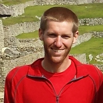 Man smiling in front of Machu Picchu ruins