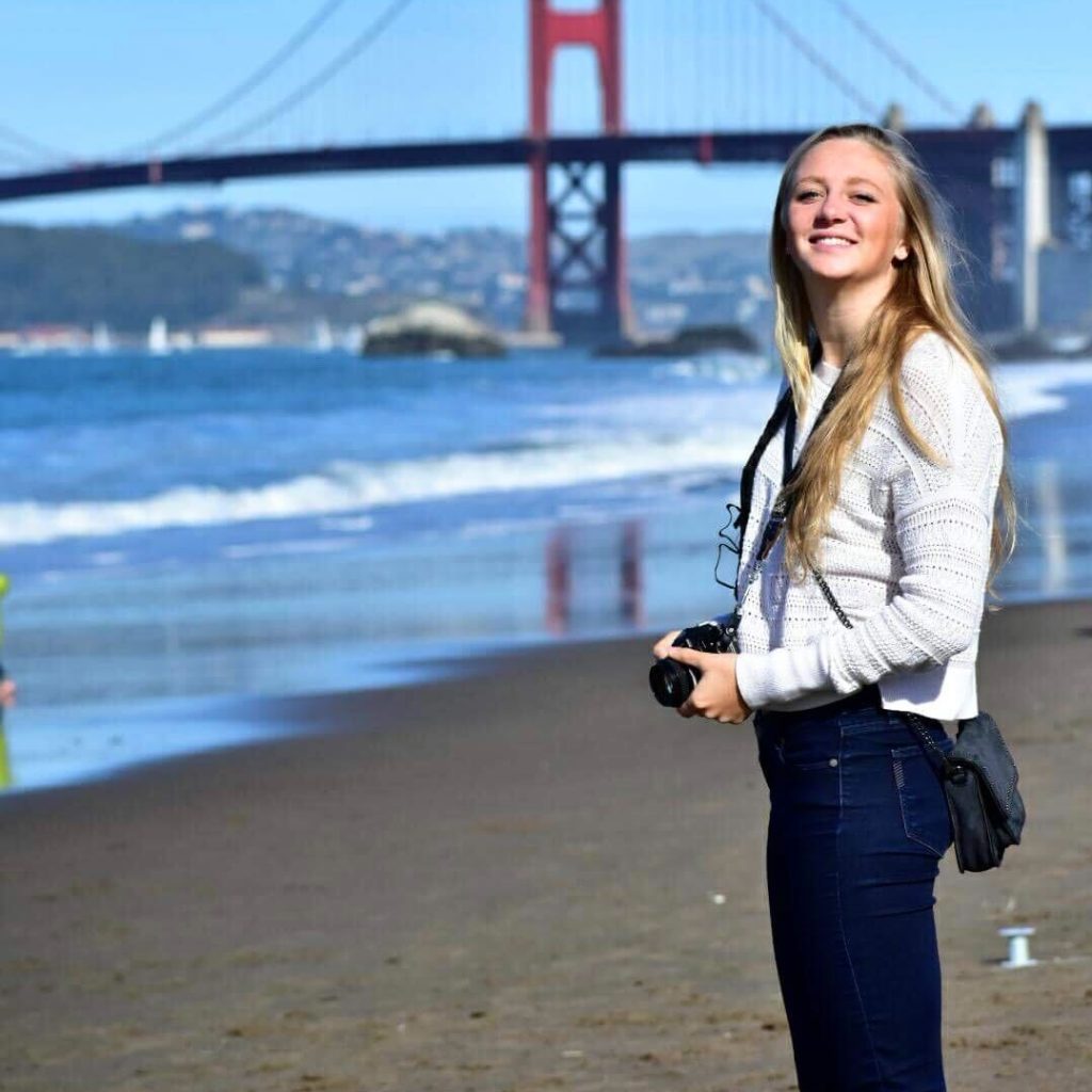 Woman with camera at Golden Gate Bridge, San Francisco.