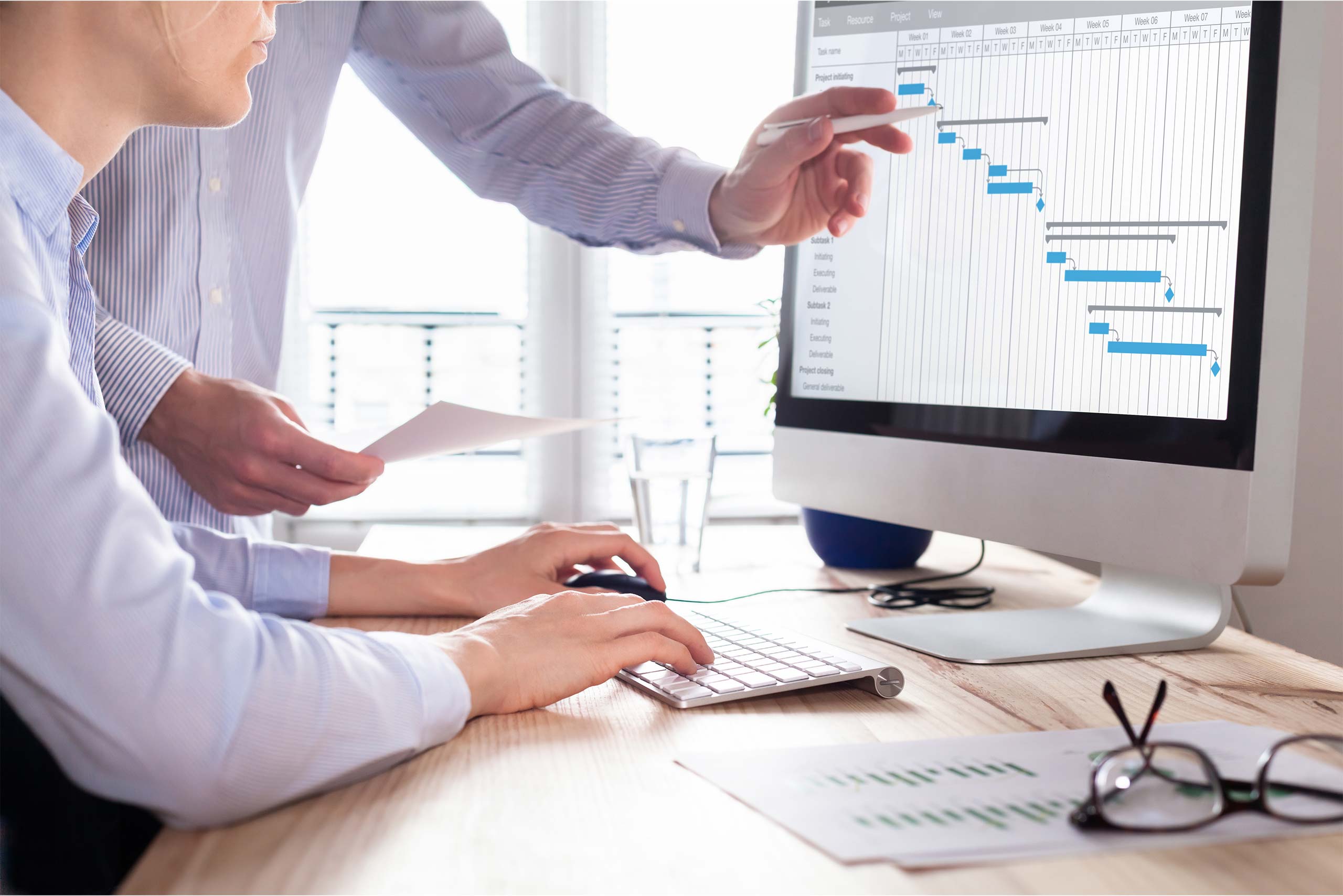 project managers working on management software on a computer