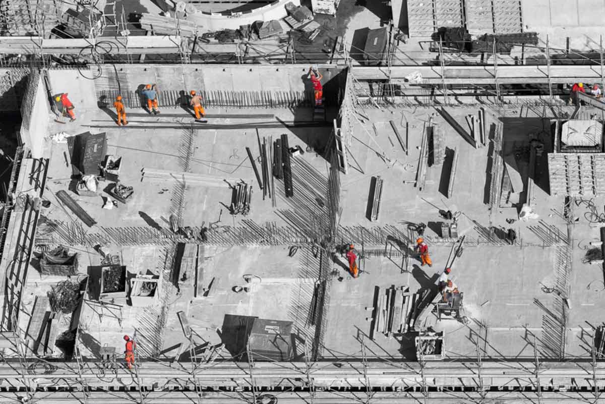 vision of a construction crew working on installing concrete using project management apps||target value design|headshot of Melanie Moreschi and Karl Schantz