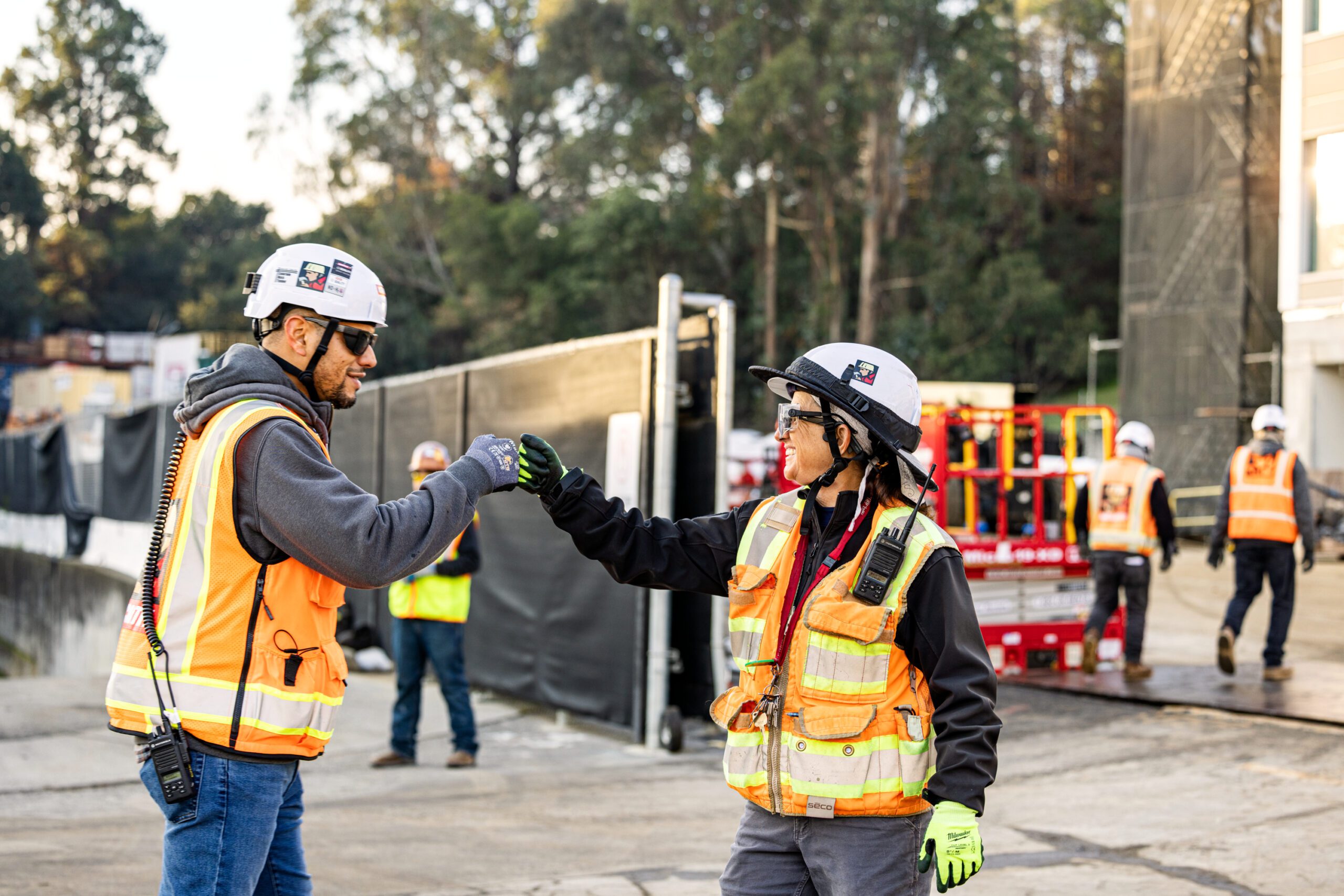Construction workers fist-bumping on the Google YouTube campus expansion project.