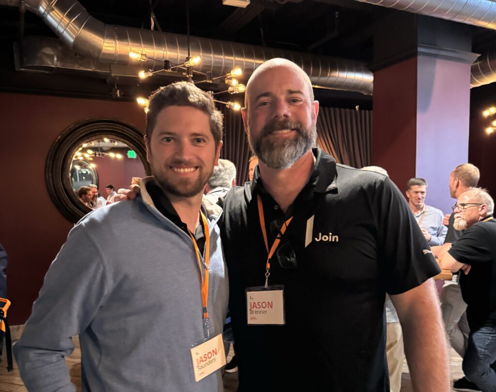 Two men pose indoors; one name tag reads "Jason Brenner, Join.