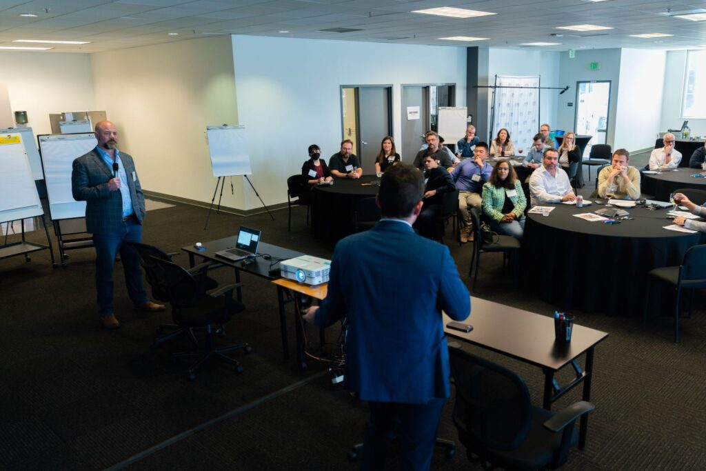 Group at industry event, two presenters speaking.