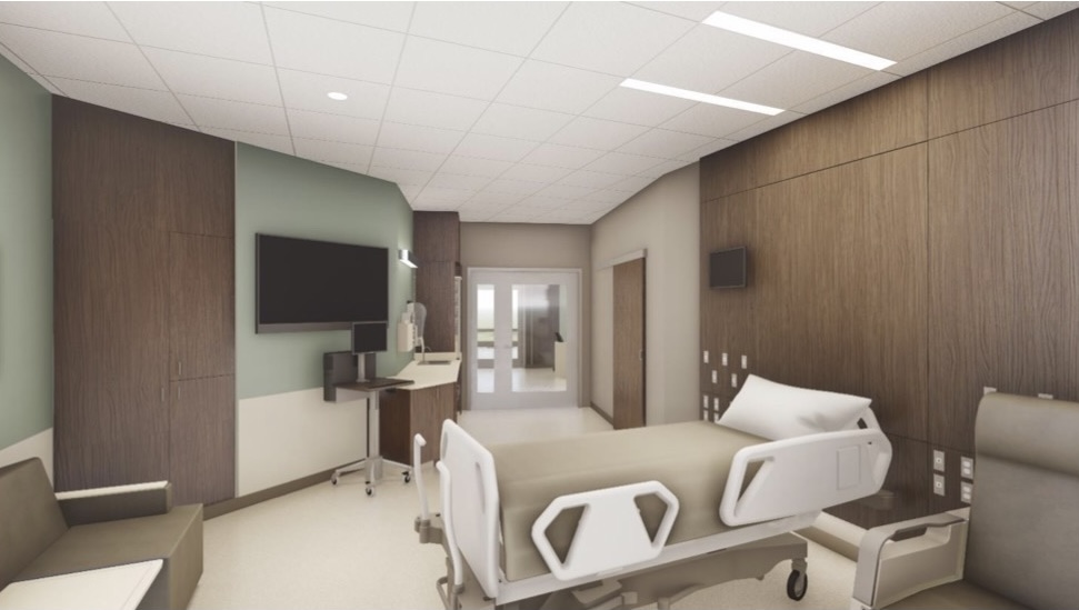 Hospital room showcasing patient bed, TV, and seating area.